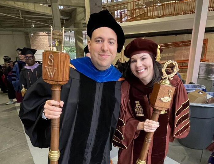 Jaime Fuentes Balderrama, left, holds a ceremonial mace ahead of UT's commencement ceremony.